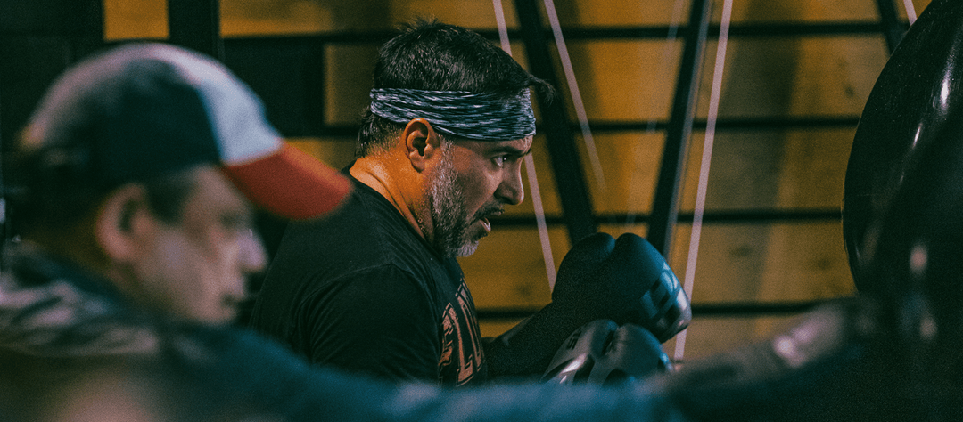 Two people lean over training equipment during a class.